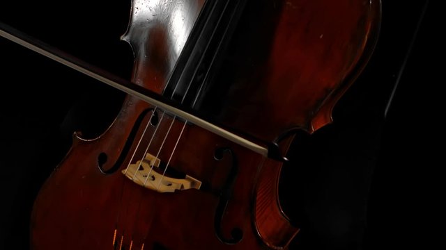 girl calmly playing cello in dark