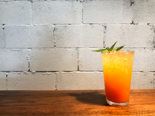 Ginger Punch glass cup was placed on a wooden table with a backdrop of white brick blocks