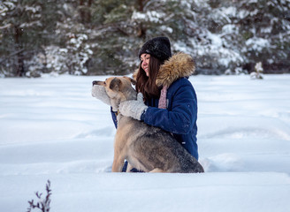 Girl plays with a cheerful dog in nature.