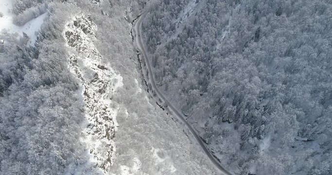 Aerial view of snow covered sunlit cliffs in the forest. Nature in winter time