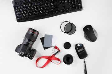 Top view of photographer workplace. Desk top view. Photo camera with big macro lens and photo equipment. Flat lay view