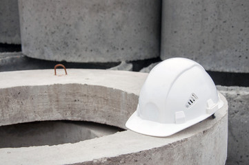 White construction helmet on concrete background.