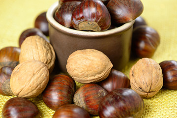 Portuguese chestnuts and walnuts in ceramic pot over yellow jute