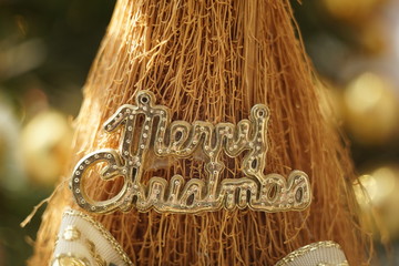 Gold text Merry Christmas on a toy broomstick. New Year Card Design.