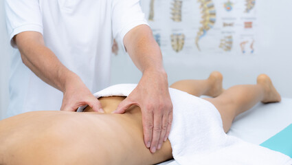 Young woman receiving a low back massage in a physiotherapy center