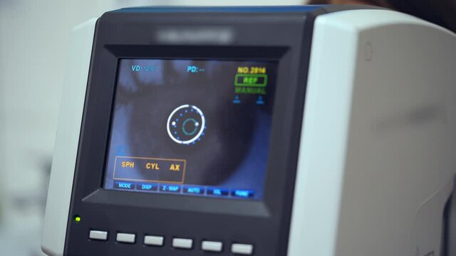 Auto refractometer testing human eye. Data screen showing progress of an eye examination. Vision concept.