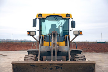 Front-end loader at a construction site. Big loader close-up.