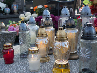 Monument and candles in the cemetery. All Saints Day in Poland. A lot of funeral candles.