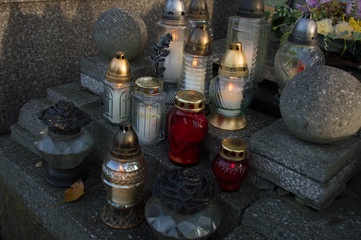 Monument and candles in the cemetery. All Saints Day in Poland. A lot of funeral candles.