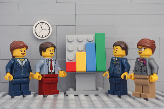Tambov, Russian Federation - November 23, 2019 Lego minifigure businessmen having a meeting and discussing graphs showing the results of their successful teamwork.