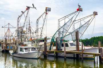 Fototapeta na wymiar Shrimp boats docked at harbour in Alabama fishing village