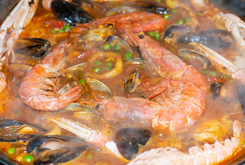 Obraz na płótnie Canvas Details of a typical Spanish paella of arrzoz with prawns, squid, sepia, mussels and monkfish.