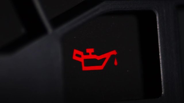 Color image of a car's oil icon lighting up on the dashboard.