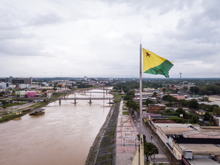 Aerial drone view of Acre river and flag in the amazon. Rio Branco city center buildings, houses,...
