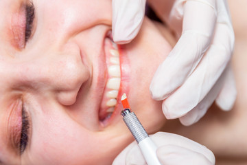 Naklejka premium Cosmetic procedures for the treatment of eyebrows. Microblading in the beauty salon. Professional cosmetology. The process of applying the pigment.