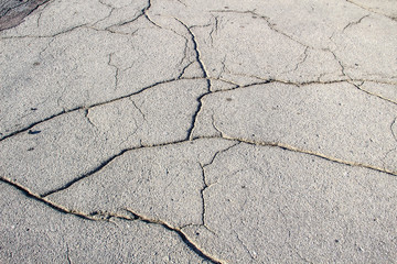 A Cracked asphalt. A background of asphalt. Cracks.