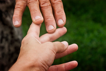 Touching the hand of the old grandmother and a young girl close-up