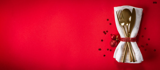 Christmas tableware and decorations on red background, top view