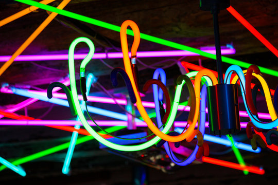 detail of a chandelier built with neon and other neon lights in the background