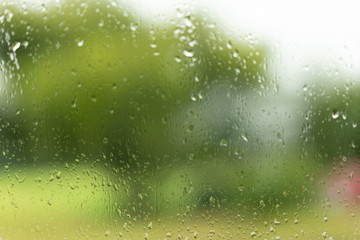 View through a wet glas, green unsharp background