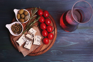 Blue cheese gorgonzola, capers, olives, tomato and decanter with wine. Snack set, italian antipasto or spanish tapas bar, selection of food on table in restaurant, top view    