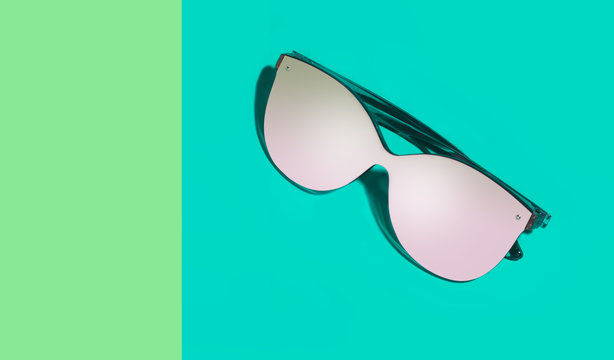 Fashionable eyeglasses with empty glasses on green different shades background