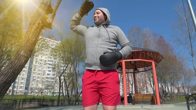 Slow motion, funny boxer in boxing gloves runs on spot