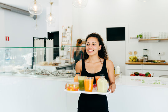 Cheerful Waitress Serving Healthy Drinks For Friends