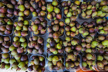 Background of fresh green and purple figs for sale in the market.