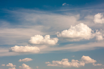 Fototapeta na wymiar Cumulus clouds gently moving across the summer blue sky