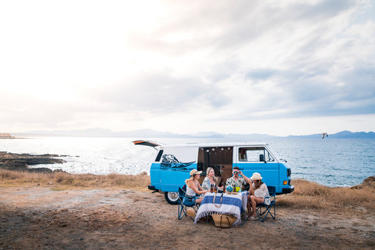 group of friends sitting in chairs next to a minivan