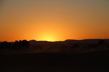 Orange sunset from the Berber camp of the Merzouga desert in the Erg Chebbi Dunes. Morocco