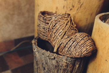 Close-up of bast shoes wickerwork hang on the drawer. National old shoes.