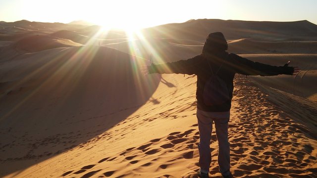 A young man at dawn in the desert of Merzouga. Morocco