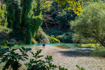 The Blue Eye (Albanian: Syri i Calter) is a water spring and natural phenomenon occurring near the village of Muzine in Finiq municipality, Albania. Young slim sexy girl posing in the water.