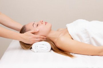 Obraz na płótnie Canvas Young woman enjoying massage in spa salon. Face massage. Closeup of young woman getting spa massage treatment at beauty spa salon.Spa skin and body care. Facial beauty treatment.Cosmetology.