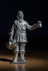 Musketeer made in white metal holding a tankard and hat male figure standing