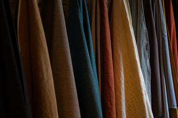 Tie-dyed fabrics from natural colors, hung on a clothesline arranged in rows. Wool