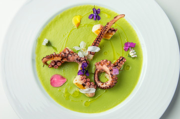 Grilled octopus on pea cream with flowers
