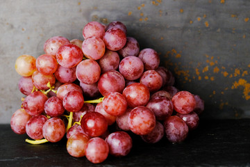 Tasty fresh grapes on dark rustic background.