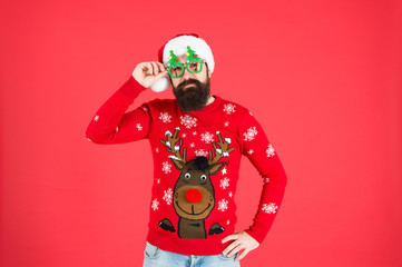 santa man party glasses. man santa hat red background. merry christmas. hipster man reindeer on knitted sweater. winter holiday. cold season clothes. happy new year. red is christmas color