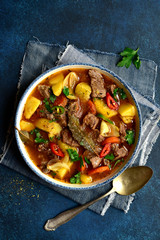 Beef stew with vegetables in a white bowl. Top view with copy space.