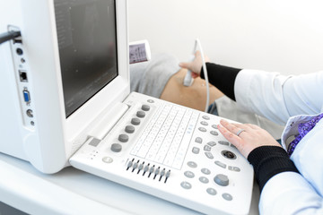 Close-up ultrasound machine doctor performs ultrasound diagnosis of the abdomen and internal organs of the patient.