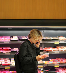 man purchasing a packet of meat at the supermarket