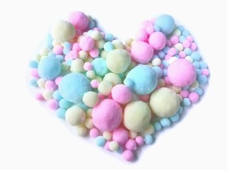 Variety size colorful pom pom made from fiber arrange beautiful heart shape on white