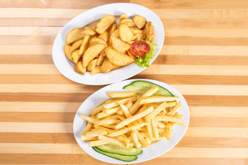 French fries slices, and chopsticks on a plate. With greens.