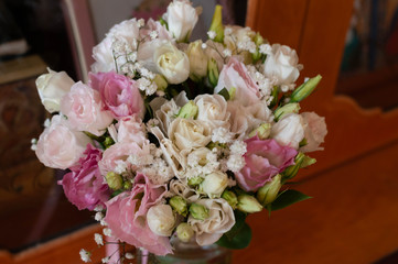 selective focus of bridal bouqet with red, pink flowers and in front of wooden surface at home