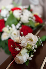 selective focus of groom boutonniere with red and white roses on couch at home