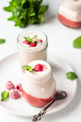 Healthy layered raspberry and yogurt smoothie or cocktail in mason jar with fresh berries and mint. Well being and weight loss concept. Natural detox.