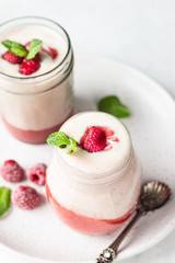 Healthy layered raspberry and yogurt smoothie or cocktail in mason jar with fresh berries and mint. Well being and weight loss concept. Natural detox.